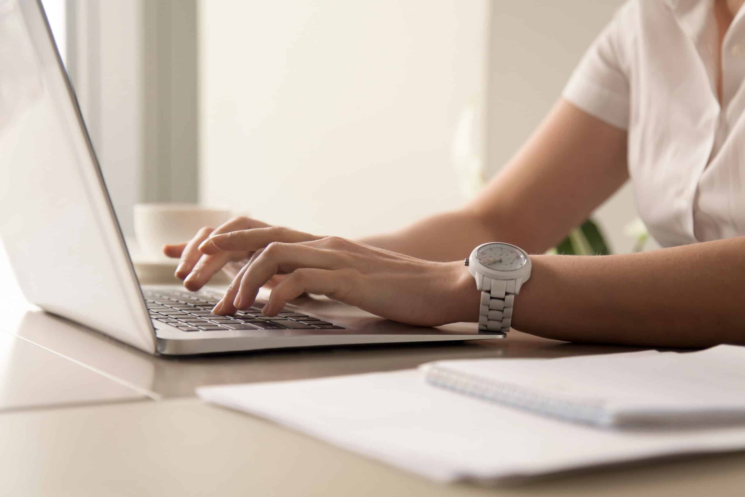 Woman typing on a laptop at a desk