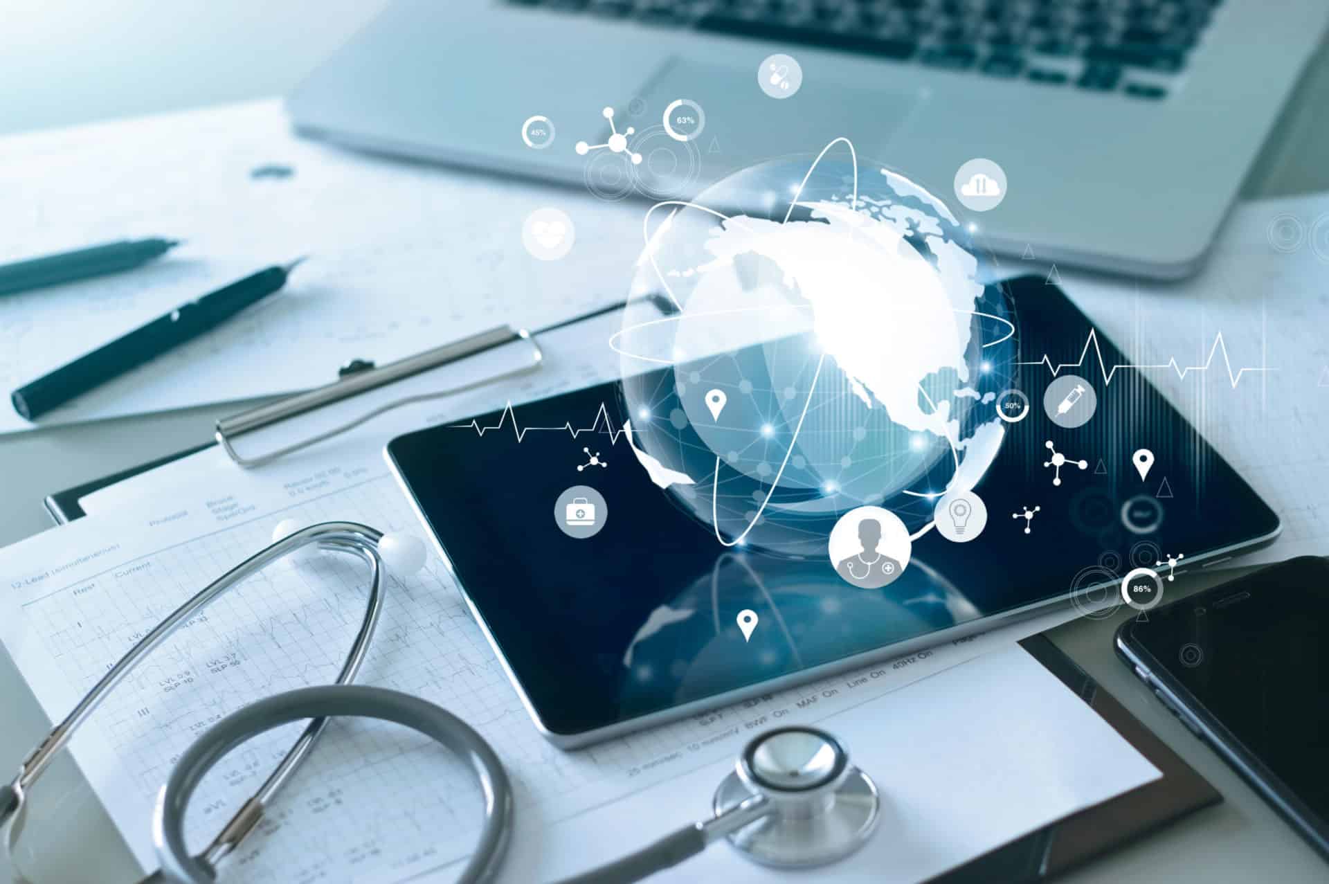 Tablet with a glowing globe and healthcare icons on a desk with a stethoscope and clipboard
