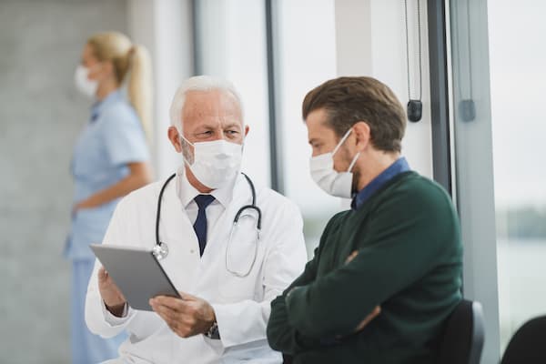 Doctor Holding Ipad Talking With Patient